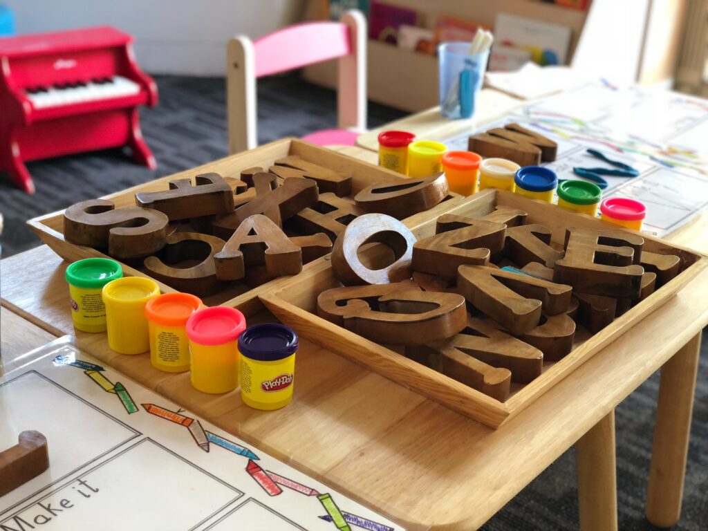 Image of a child's play station with letter blocks and Play-Doh