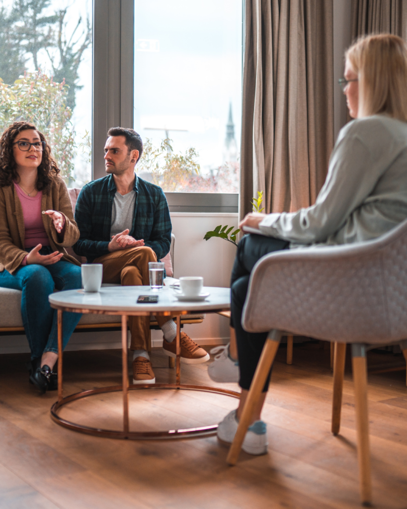 Image of a man and woman in counseling together with a therapist listening.