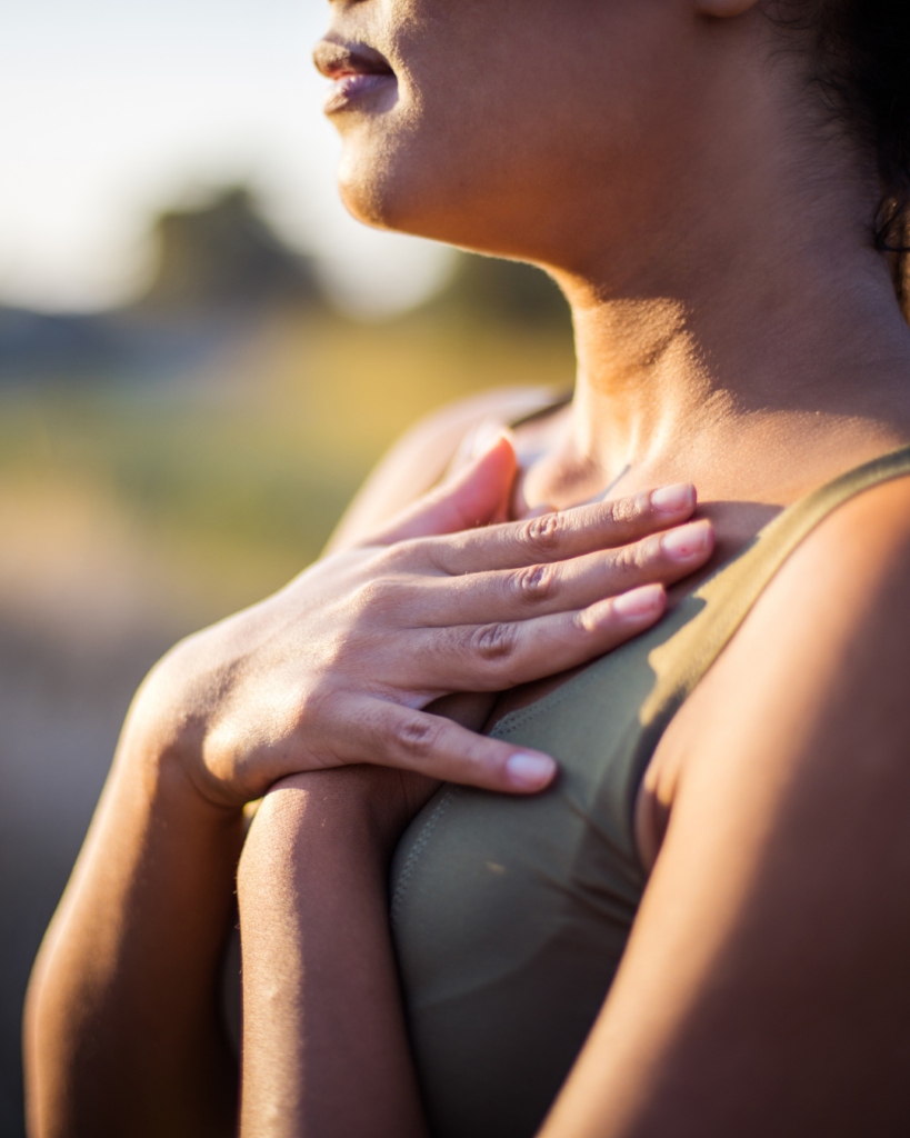 Photo of a woman with her hands on her chest taking a breath.