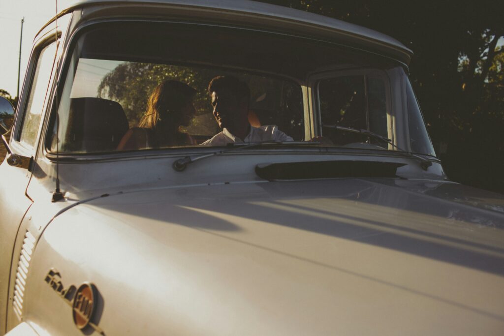 Photo of a couple in a truck looking at each other and smiling